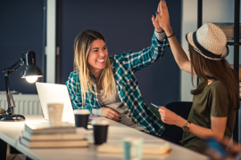 Two ladies give each other a high five after signing the lease