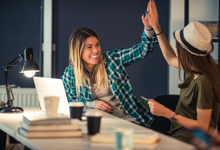 Twee dames geven elkaar een high five na het tekenen van het huurcontract