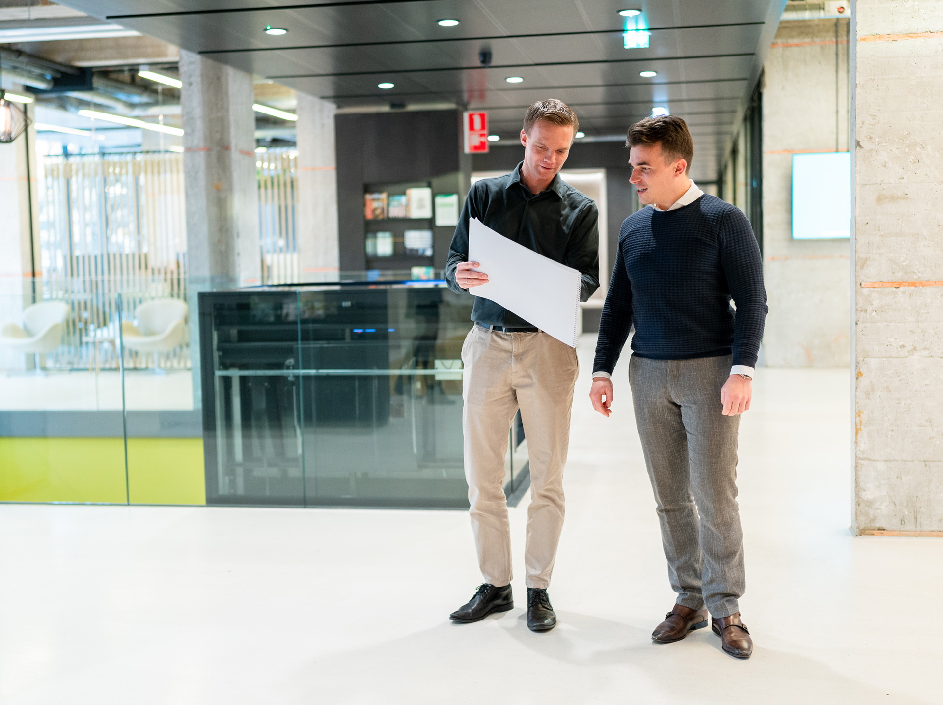 Twee collega's in gesprek met elkaar op het hoofdkantoor